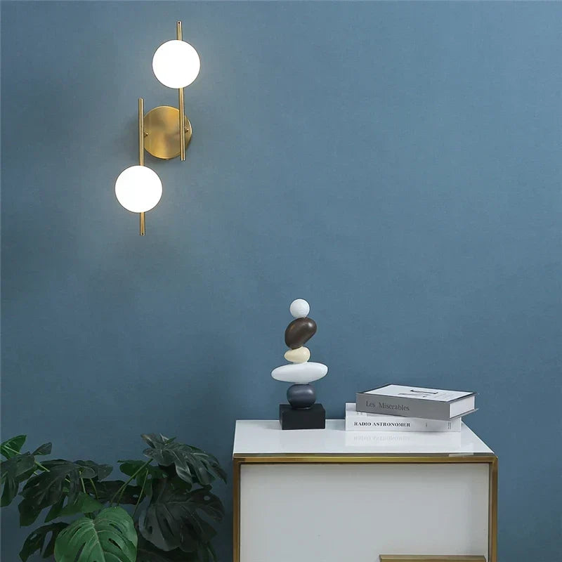 Lámpara de pared dorada con esfera de vidrio esmerilado