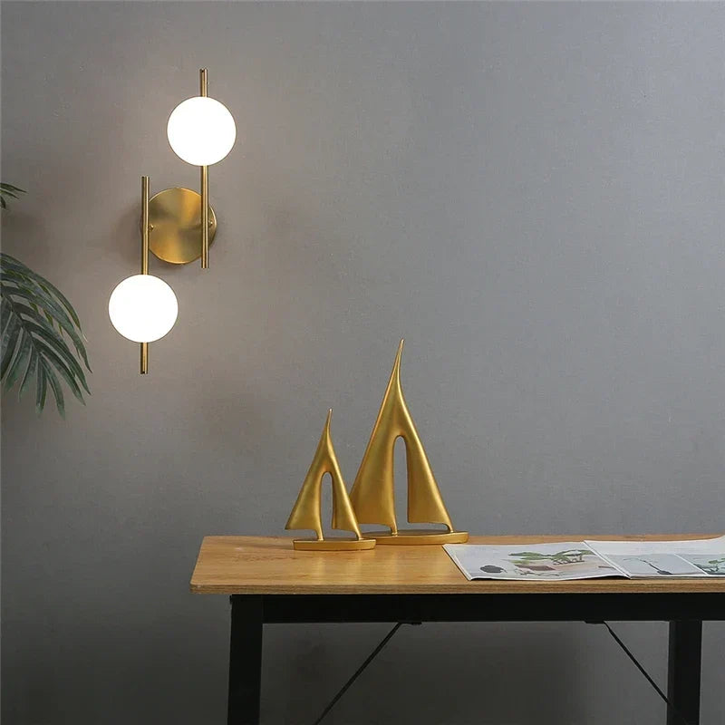 Lámpara de pared dorada con esfera de vidrio esmerilado
