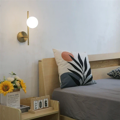 Lámpara de pared dorada con esfera de vidrio esmerilado